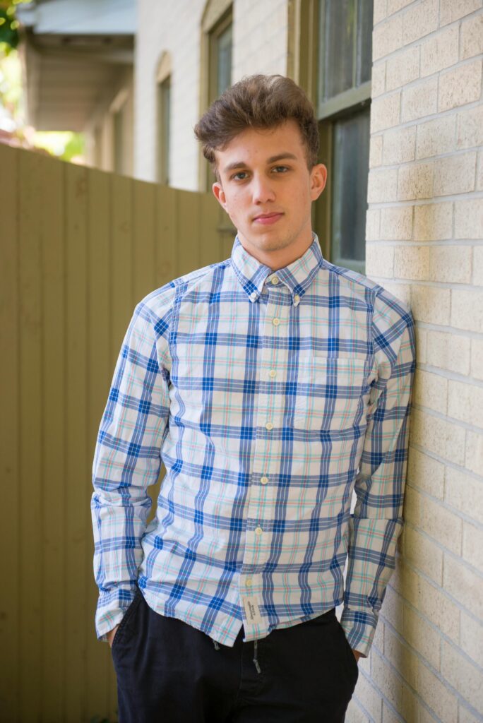 Image of a young man leant against a wall